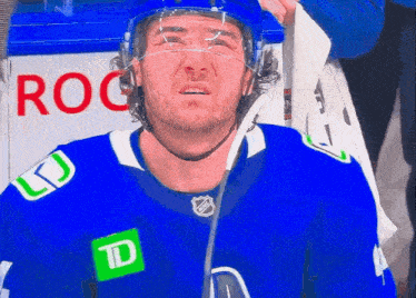 a hockey player in a blue jersey with a td logo