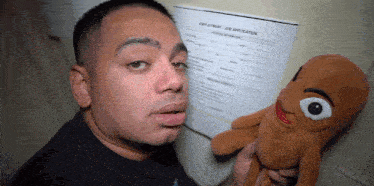 a man holding a stuffed animal in front of a job application