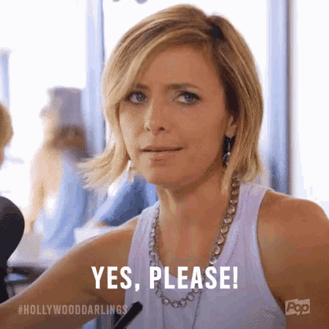 a woman is sitting in front of a microphone and says yes , please !