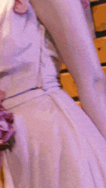 a woman in a purple dress with purple flowers on the sleeves