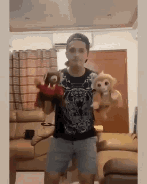 a man is holding two stuffed animals in his hands in a living room