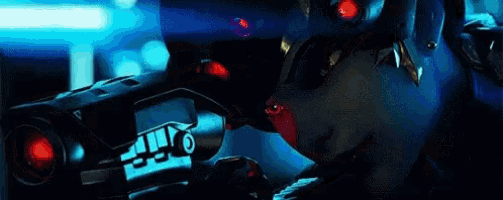 a woman in a futuristic suit is holding a gun in a dark room .