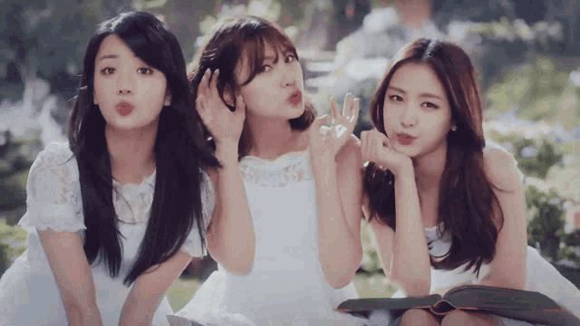 three women in white dresses are standing next to each other