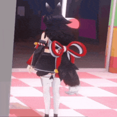a girl with a red bow on her back is standing in a room .