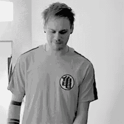 a black and white photo of a man wearing a t-shirt with a dragon ball z logo on the front .
