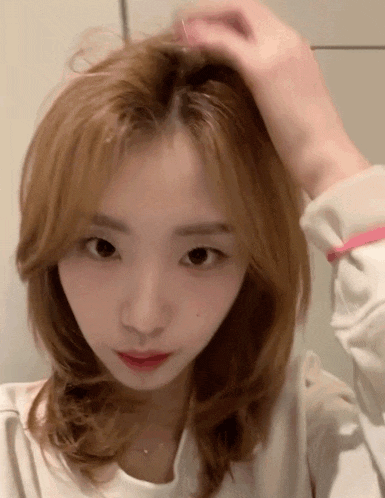 a close up of a woman 's head with a person holding her hair