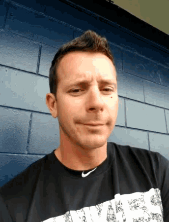 a man wearing a nike shirt is making a face