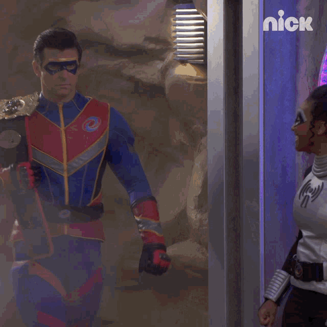a man in a superhero costume stands next to a woman in a superhero costume with a nick logo in the background