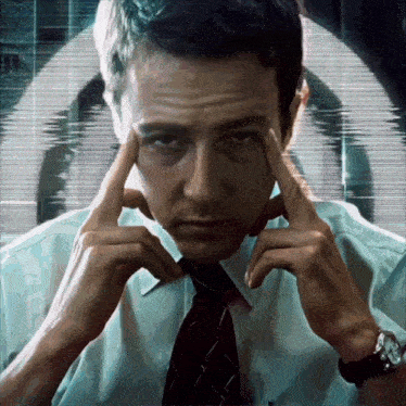 a man with his hands on his forehead looks at the camera