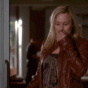a woman in a leather jacket is covering her mouth with her hand .