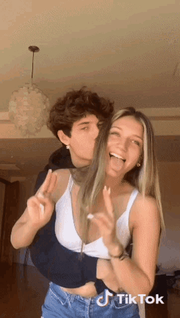 a man kissing a woman on the cheek with a tiktok logo on the bottom right