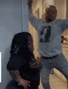a man and a woman are standing next to each other in a room .