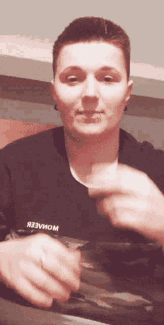 a man wearing a black shirt with the word wowaeer on the front