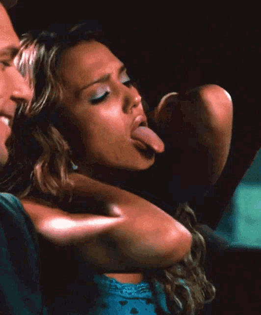 a woman sticking her tongue out while a man holds her