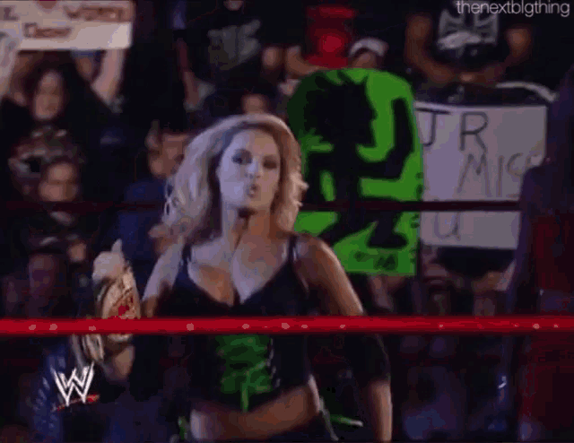 a woman in a wrestling ring holds up a sign that says jr