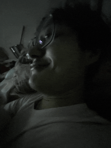 a close up of a person wearing glasses and a white shirt