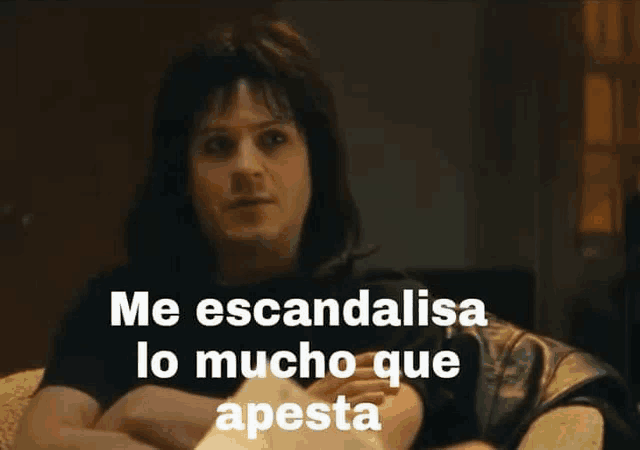 a man is sitting on a couch with his arms crossed and a caption that says `` me escandalo lo mucho que apesta ''