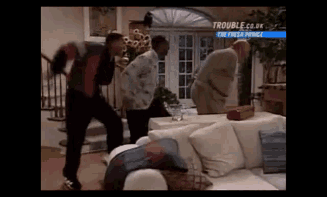 a group of men are dancing in a living room .