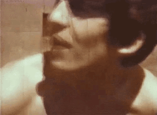 a close up of a man 's face with a mustache in a bathroom .