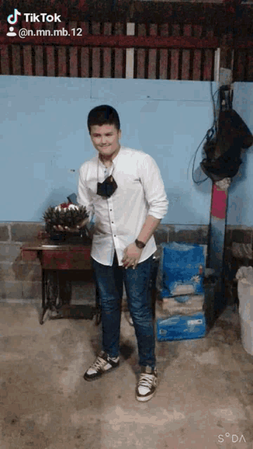a man wearing a mask is standing in front of a sewing machine and a sign that says tik tok on it