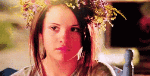a young woman wearing a flower crown on her head .