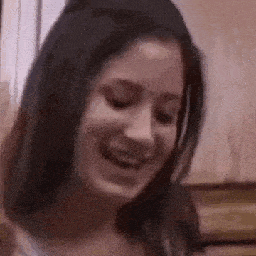 a close up of a woman 's face with her eyes closed and a smile on her face .