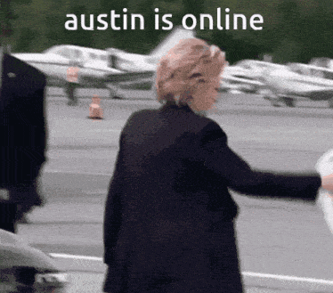 a woman in a black coat is walking on a runway with a caption that says " austin is online "