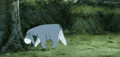 eeyore from winnie the pooh is sleeping in the woods .