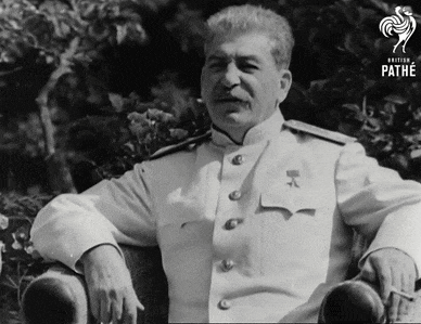 a man in a white uniform is sitting in a chair with his arm resting on the arm of the chair