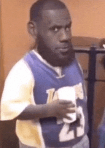 a man with a beard is holding a cup of coffee in his hand .
