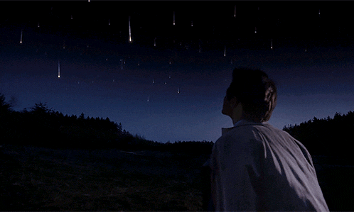 a person looking up at a night sky with a lot of stars