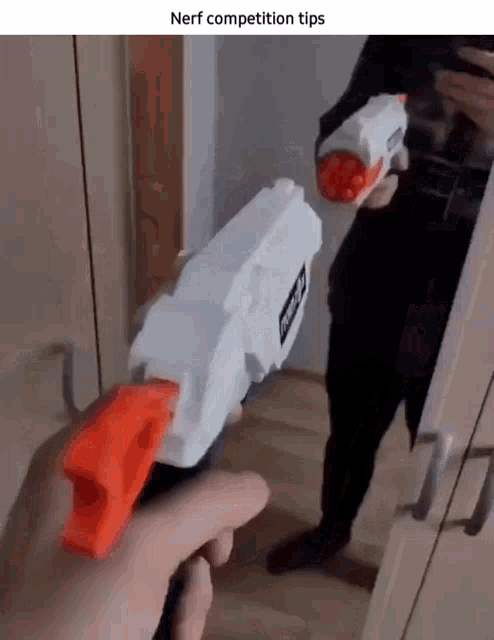 a person is holding a nerf competition gun in front of a mirror