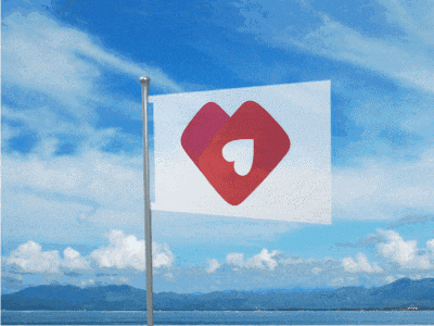 a white flag with a red heart on it is flying in the wind