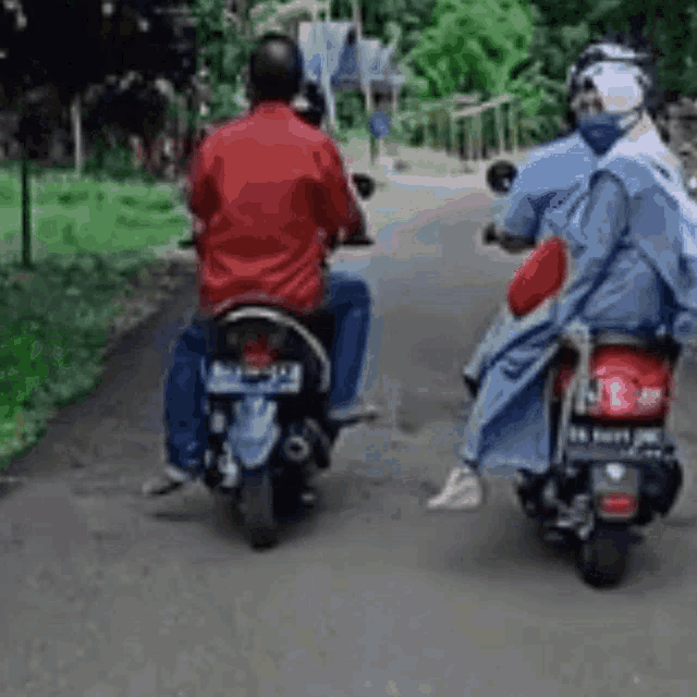 a man and woman are riding motorcycles down a road .