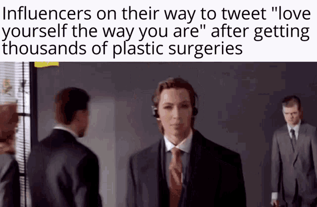 a man in a suit and tie talks to another man in a suit