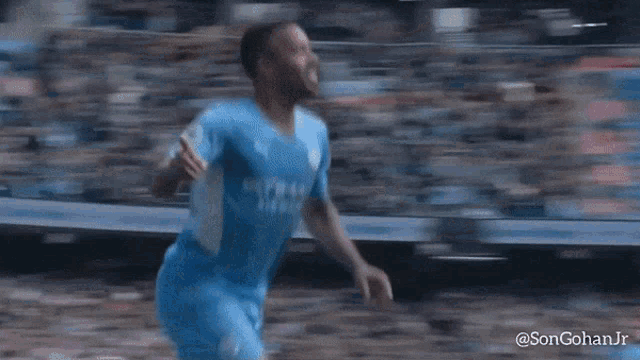 a soccer player wearing a blue etihad jersey is running
