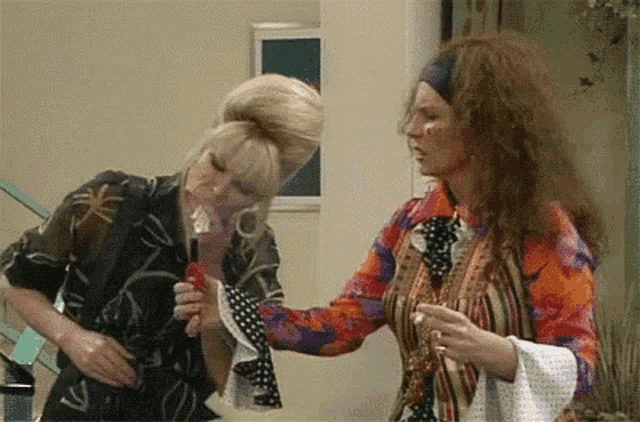 two women are standing next to each other and one of them is wearing an oxygen mask