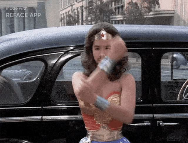 a woman dressed as wonder woman is standing next to a car .