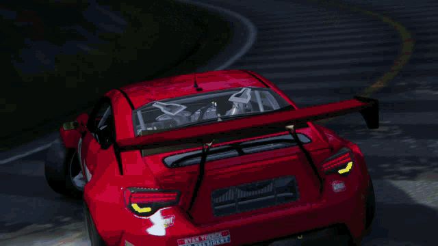 a red car with gunout on the side is driving down a road