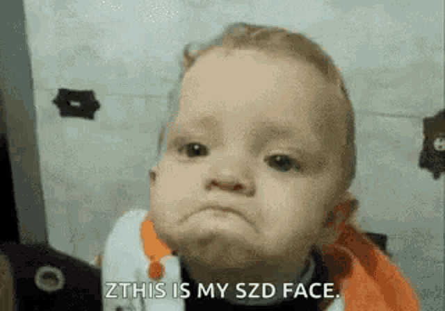 a baby is making a funny face and saying `` zthis is my szd face '' .