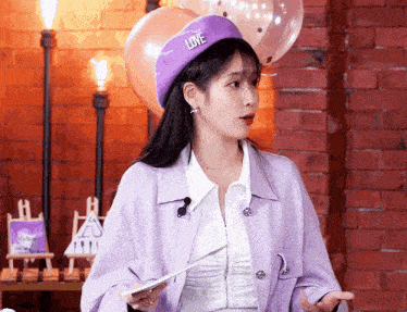 a woman wearing a purple hat with love on it