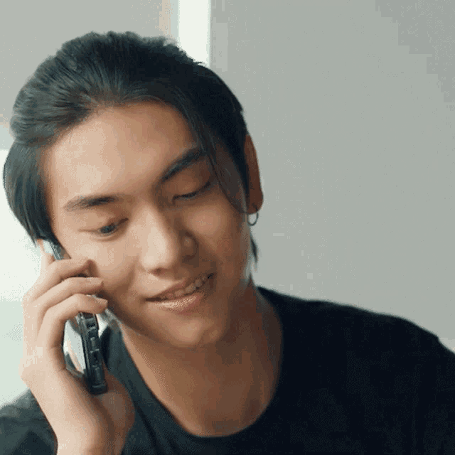 a man in a black shirt is talking on a cell phone with a white background