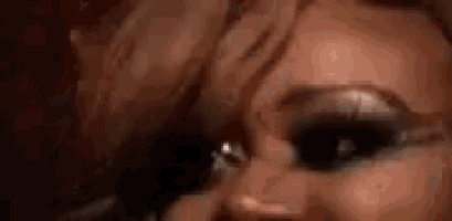 a close up of a woman 's face with smokey eyes .