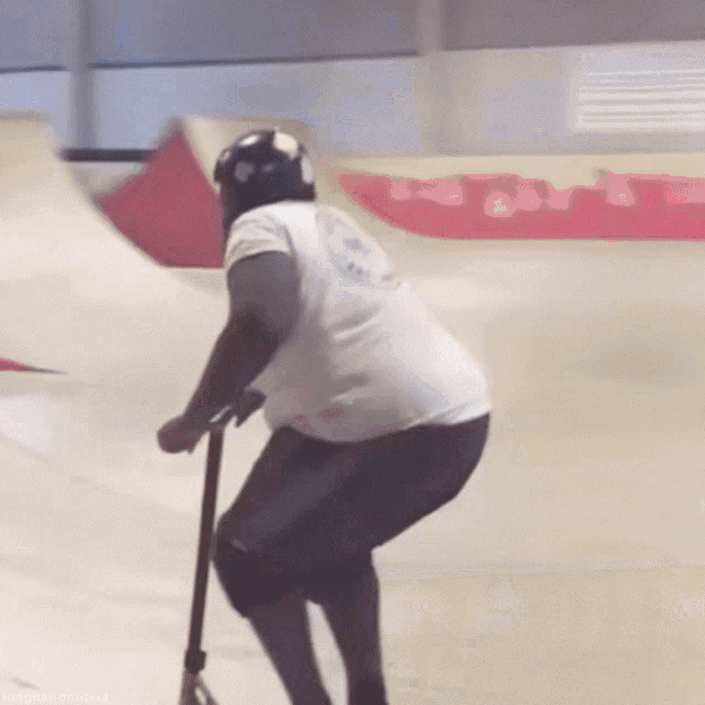 a person riding a scooter on a ramp with a white shirt that says ' i love you ' on it