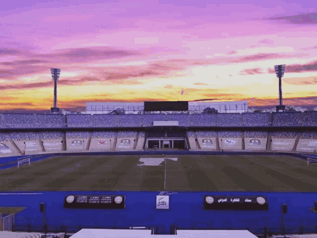 a soccer stadium with a sunset in the background