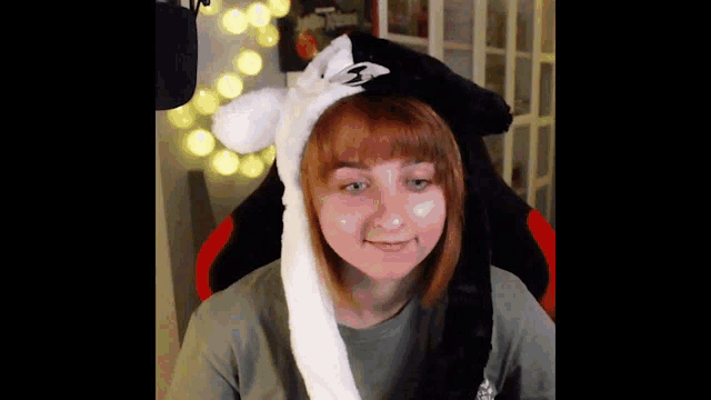 a woman is wearing a black and white hat with ears .
