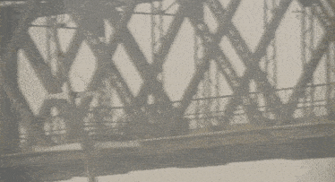 a blurred image of a bridge with a few people walking on it