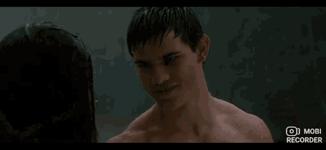 a man without a shirt is looking at a woman in a shower with mobi recorder