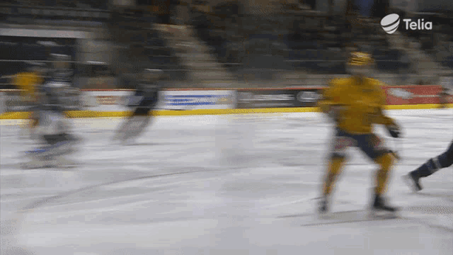 a blurry picture of a hockey game with a telia logo in the upper right corner