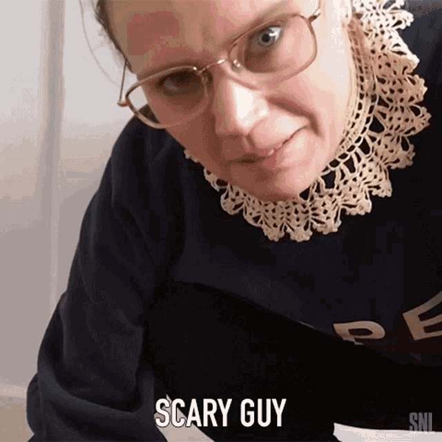 a woman wearing glasses and a sweater with the word scary guy on it